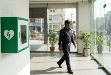 A public access AED mounted in an office lobby, placed to be reached within three minutes