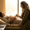 Midwife using a pocket fetal doppler to listen to the baby’s heartbeat